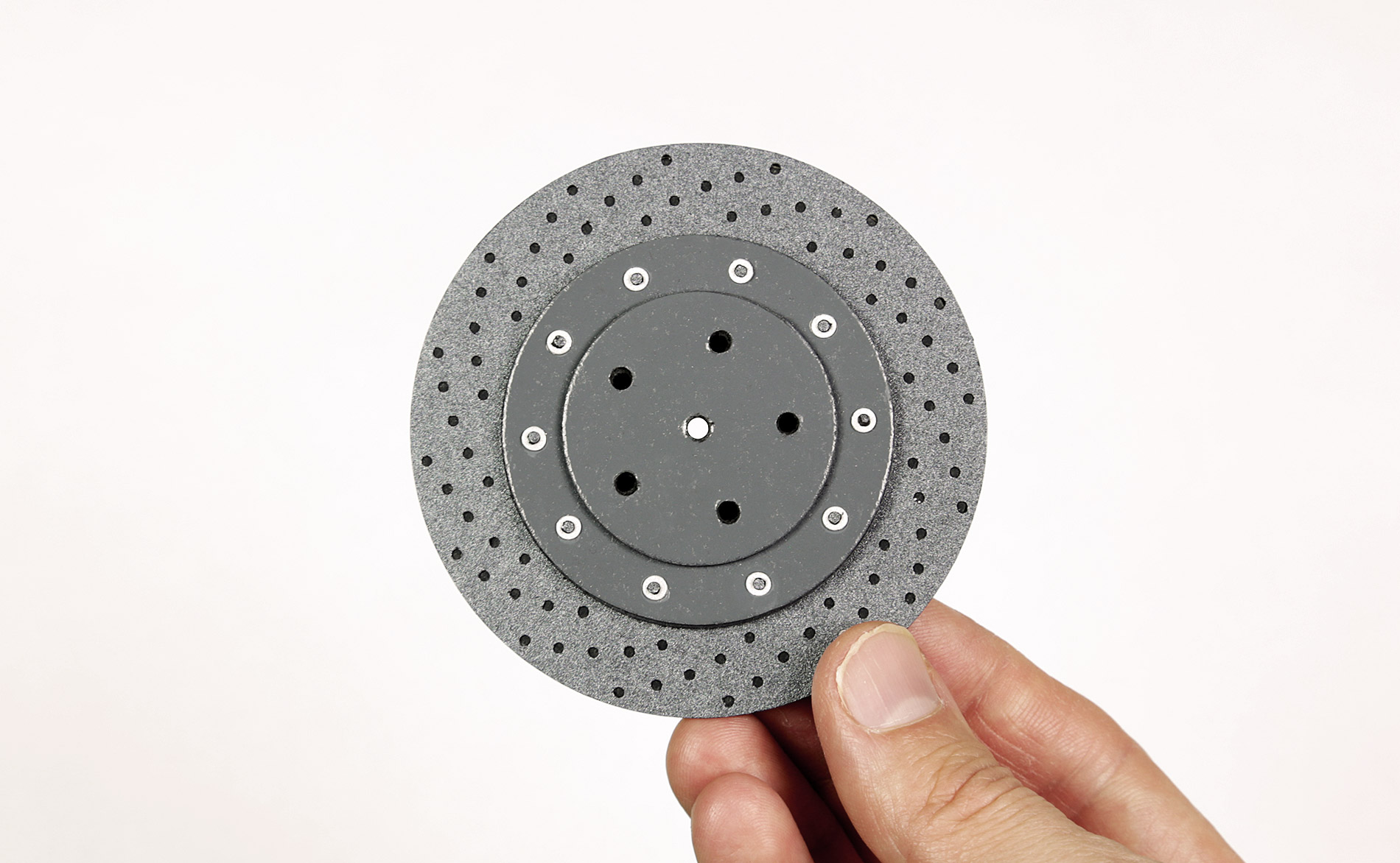 Rear carbon ceramic disk brake rotor cut from craft card and board.