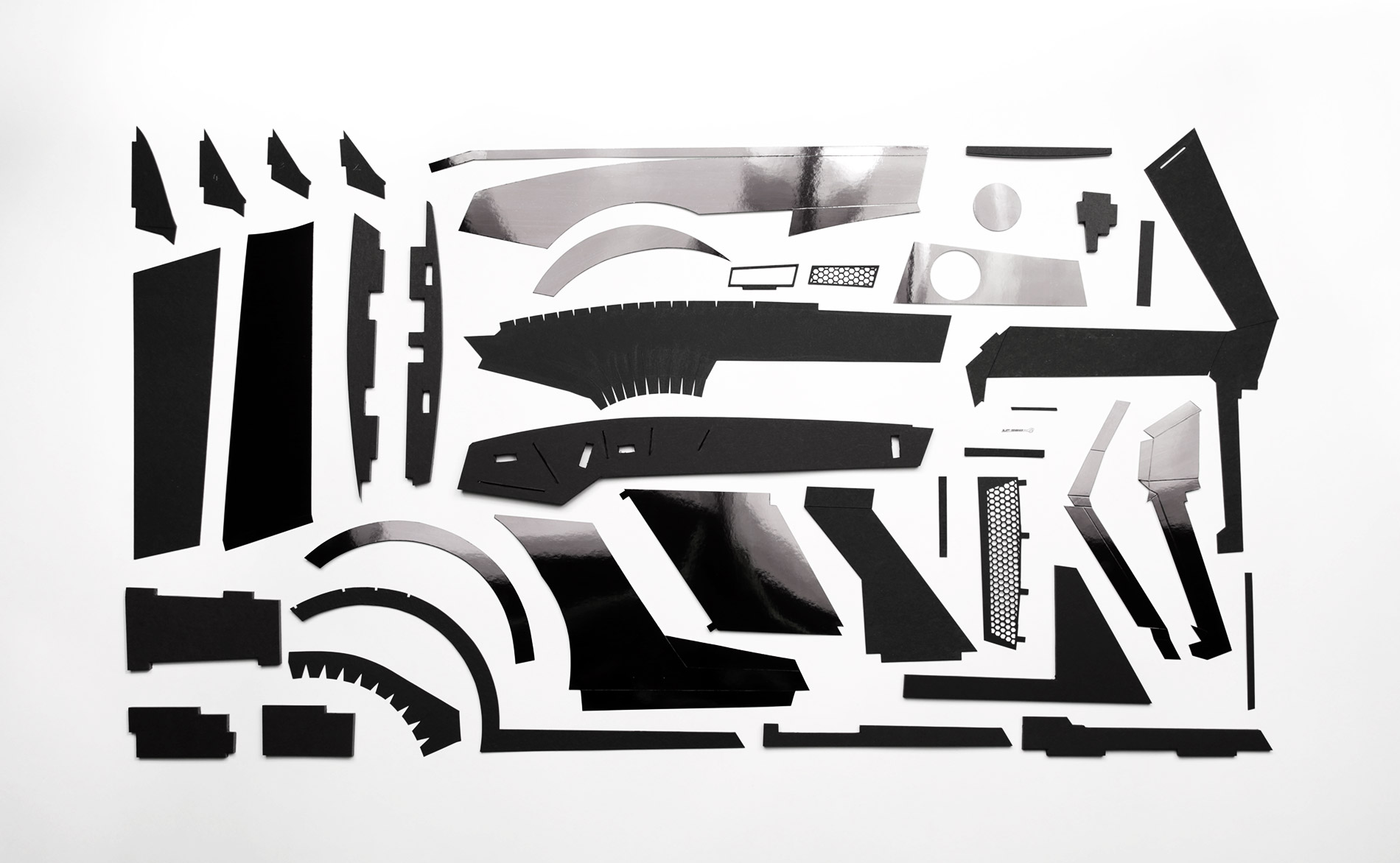 I spent three months designing and perfecting all the individual parts for rear fenders, oil coolers, and tail lights. Here are all the parts for one rear fender. Designed from scratch, plans drawn in Illustrator, printed, then cut by hand.